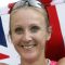 Paula Radcliffe smiling while holding a flag of the United Kingdom